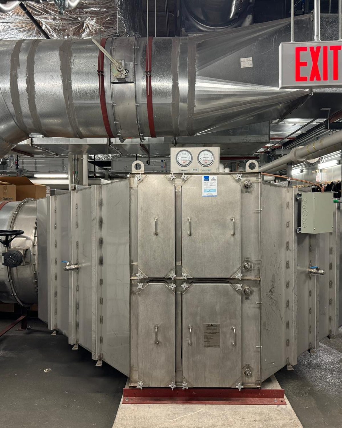 Stainless steel HEPA filter housing in a mechanical penthouse with magnehelic gauges and spiral ductwork