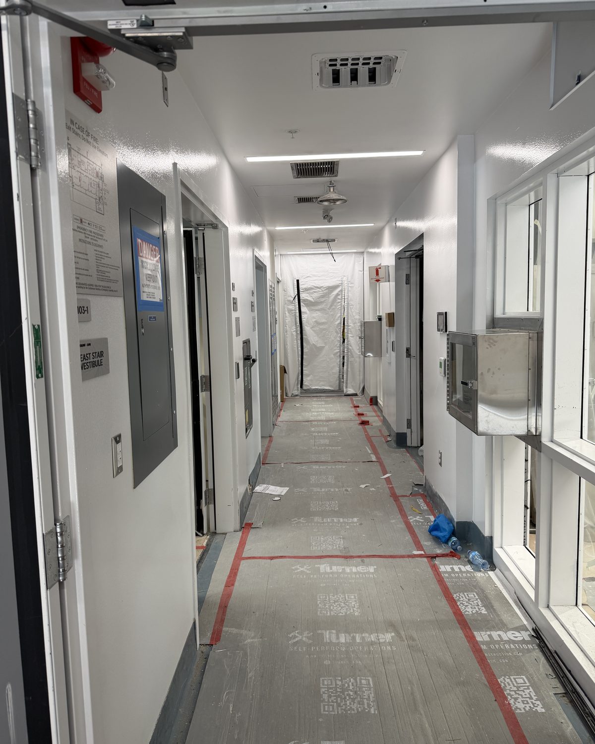Cleanroom corridor under construction with floor protection and temporary containment barriers