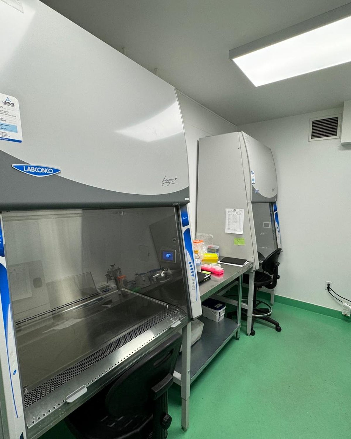 Class II Type A2 biosafety cabinets in a research laboratory with Clean Air Monitoring certification tag visible